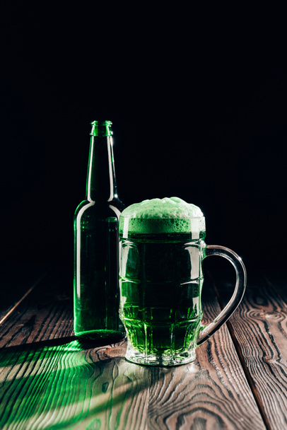 vidro e garrafa de cerveja verde na mesa de madeira, st patricks conceito dia
 - Foto, Imagem
