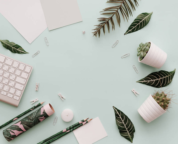 Home Pastel Office Desktop with green tropical leaves, keyboard, botanical element. - Foto, imagen