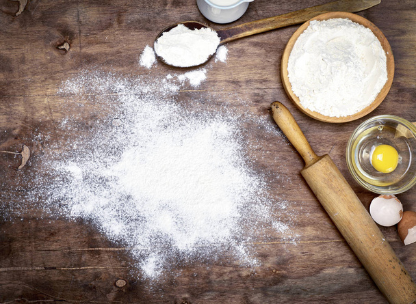powdered flour on a brown wooden background - Valokuva, kuva