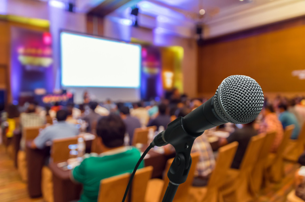 Microfono sulla foto astratta sfocata della sala conferenze o sala seminari con sfondo partecipante
 - Foto, immagini