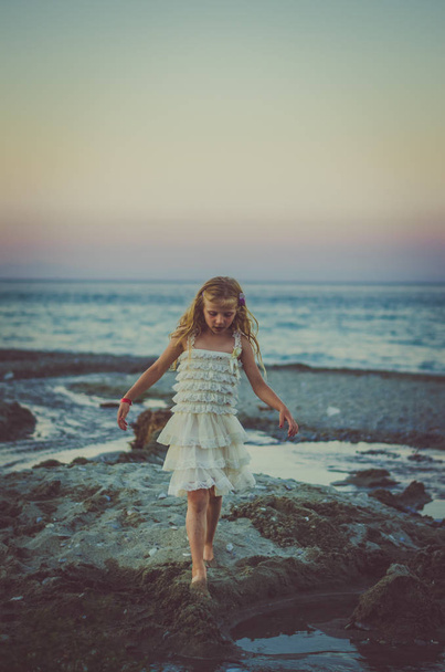 lapsi ja meri auringonnousun aikaan
 - Valokuva, kuva