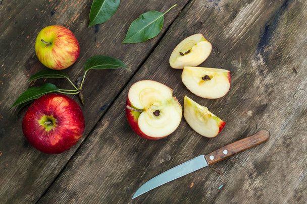 Punainen omena viipaloitu ja veitsi vanha puinen pöytä
 - Valokuva, kuva