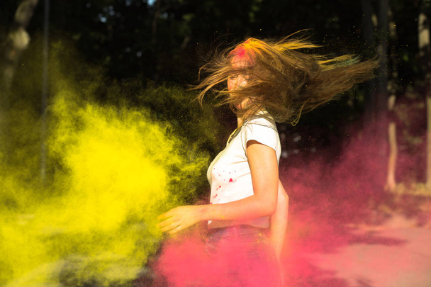 Φοβερό νεαρή γυναίκα με άνεμο στα μαλλιά και δονούμενα χρώματα explodi - Φωτογραφία, εικόνα