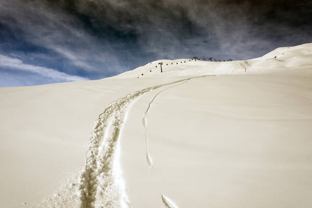  Una vista de una pista de esquí, marca de esquí y telesilla en las hermosas montañas de los Alpes en st moritz Suiza en invierno
 - Foto, Imagen