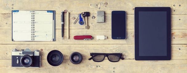 Outfit of a stylish traveler. Set of different objects and equipment: tablet, phone, album, glasses, camera, lenses, gumshoes, knife and watches - Fotografie, Obrázek