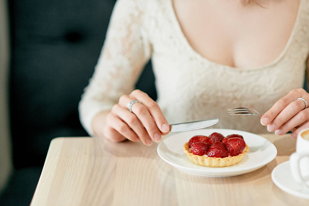 Girl eating strawberry dessert in restaurant - Foto, Imagen