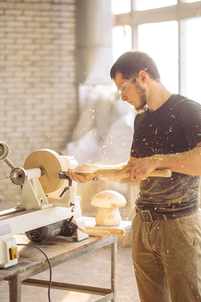 man working at small wood lathe, an artisan carves piece of wood - Foto, Imagem