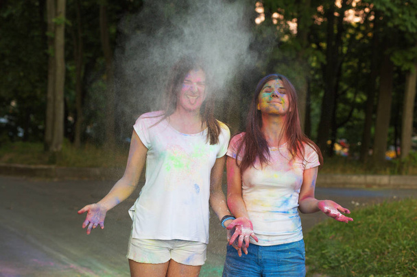 Due amici allegri che lanciano polvere bianca di Holi nel parco
 - Foto, immagini