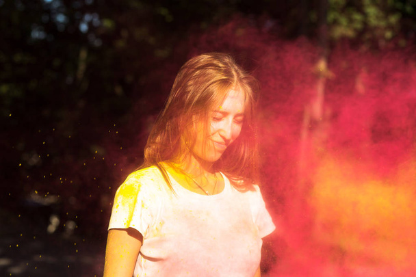 Zadowolona Blondynka zabawy z kolorowe farby w Holi festi - Zdjęcie, obraz