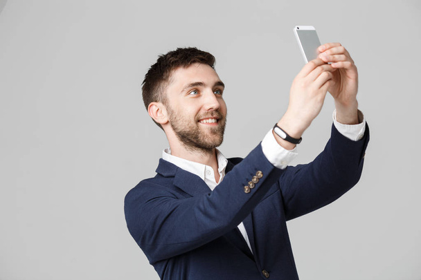 Business Concept - Muotokuva Komea liikemies ottaa selfie itsestään älypuhelimella. Valkoinen tausta
. - Valokuva, kuva