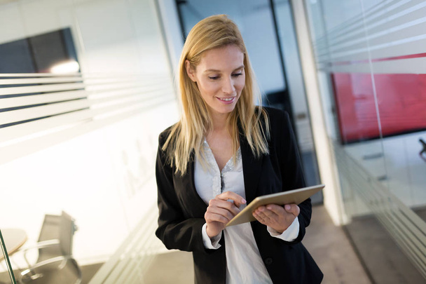 Attractive businesswoman using digital tablet in modern office - Foto, imagen