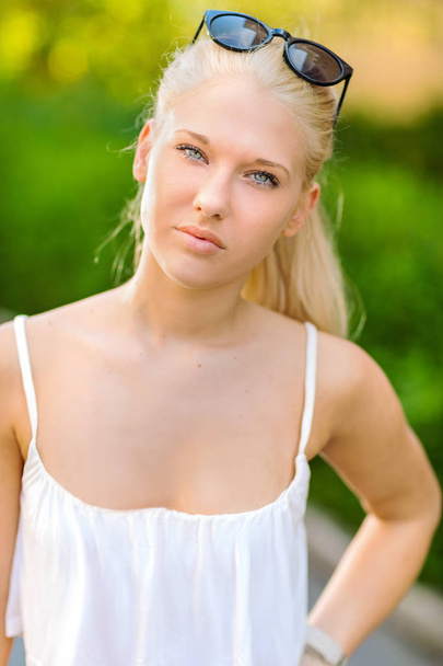Naturalny blond teen dziewczyna stojąc na ulicy w słońcu - Zdjęcie, obraz