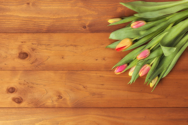 Tulpenstrauß auf einem hölzernen Hintergrund. Frühlingsblumen. Hintergrund Muttertag. - Foto, Bild