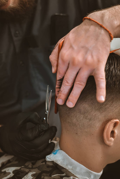 Closeup of smiling man getting an haircut from barber - Photo, image