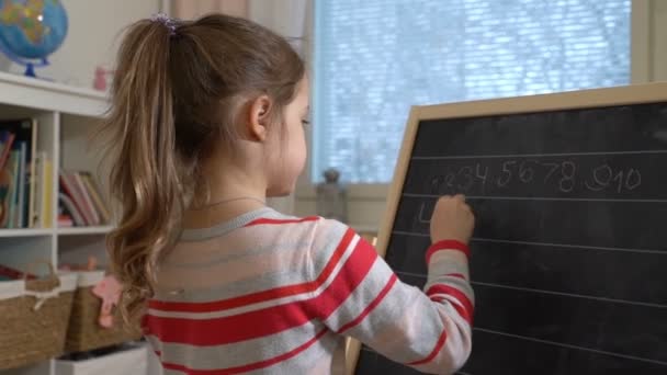 Young mother explaining arithmetic to cute little daughter at home - Materiał filmowy, wideo