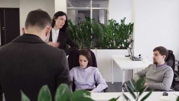 Business woman talking to her colleagues at workplace in office - Filmagem, Vídeo