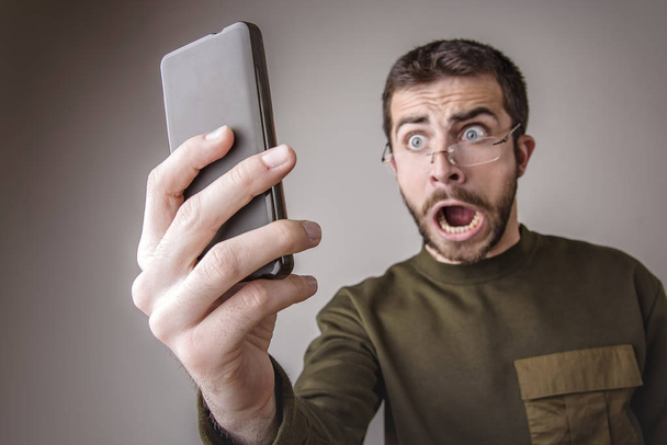 Furious man yelling at his phone - Φωτογραφία, εικόνα