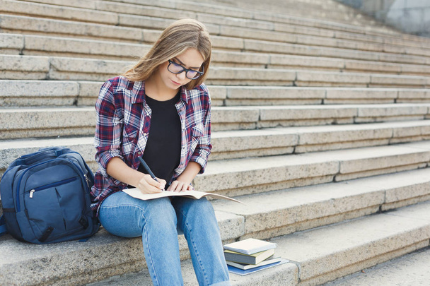 Young student girl making notes in notebook - Foto, Imagem