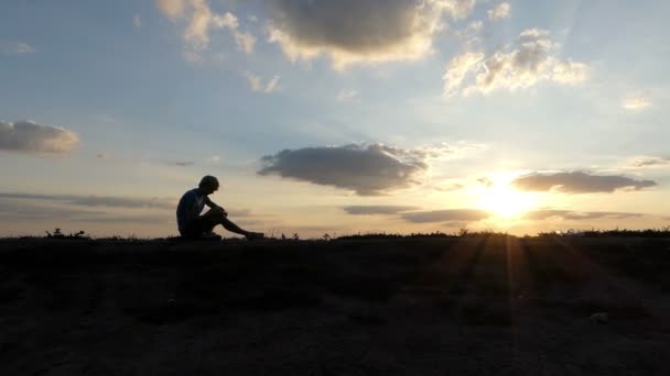 Bystrý muž píše pohádky na trávníku při západu slunce v slo-mo - Záběry, video