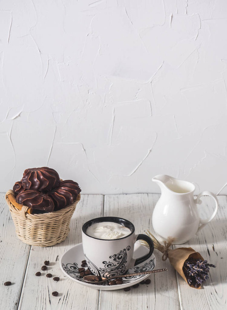 morning coffee with cream, marshmallow and a bouquet of flowers - Photo, Image