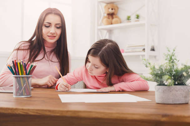 Mother helping her daughter with the homework. - Photo, Image