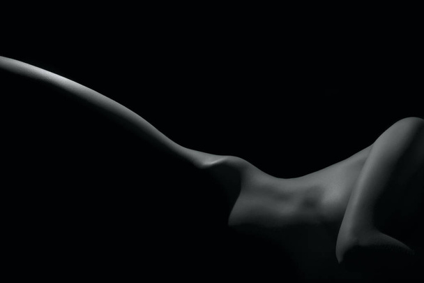 Silhueta de uma parte de corpo, mulher nua isolada em fundo preto
 - Foto, Imagem