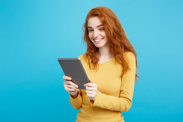 Osób i koncepcji technologii - zbliżenie dziewczyna młody piękny atrakcyjne oferty imbir redhair portret szczęśliwy uśmiechający się na cyfrowych tabeli z zdobywając coś. Niebieskim tle Pastel. Miejsce. - Zdjęcie, obraz
