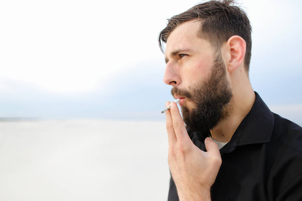   Γεωγράφος αρσενικό κάπνισμα διεξαγωγή έρευνας στην παραλία.  - Φωτογραφία, εικόνα
