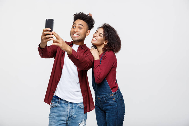 Mladá atraktivní africká americká dvojice představují pro selfie představují s chytrý telefon - Fotografie, Obrázek