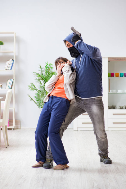 Ozbrojený muž napadá mladou ženu doma - Fotografie, Obrázek