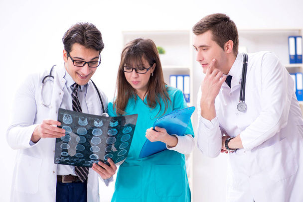 Τρεις γιατροί συζητούν τα αποτελέσματα των ακτινογραφιών - Φωτογραφία, εικόνα