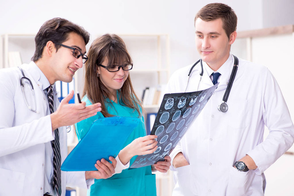 Drei Ärzte diskutieren Scanergebnisse von Röntgenbild - Foto, Bild