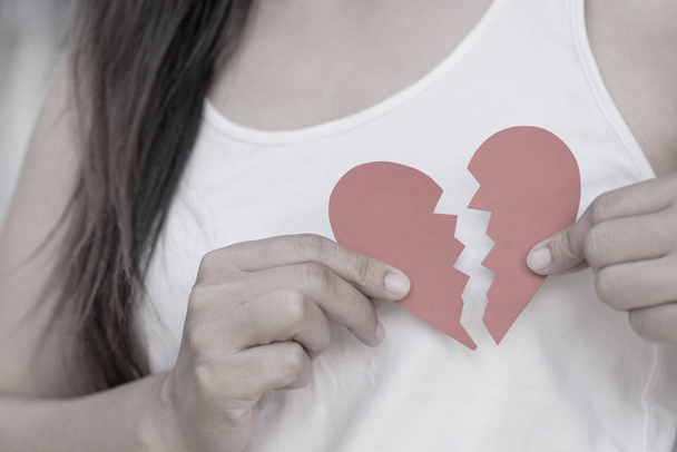 Young woman showing red ripped paper heart.  - Photo, Image
