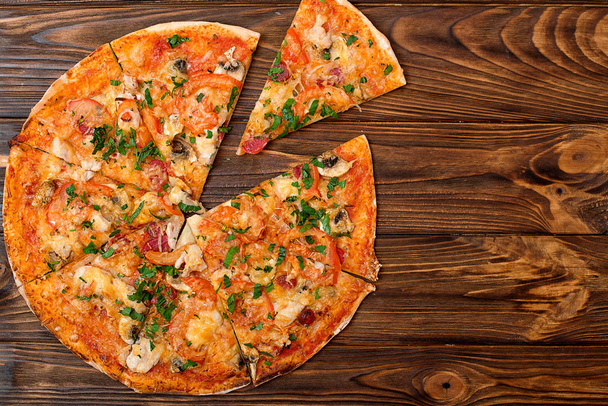  Tasty Italian pizza on a wooden table.Top view. Copy space. - Foto, afbeelding