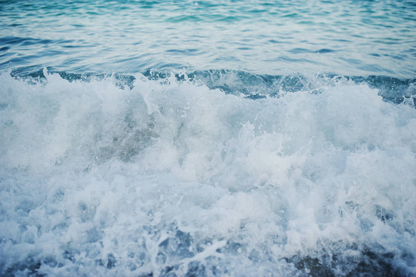 Close-up photo of waves crashing on the sand shore. - Foto, Bild