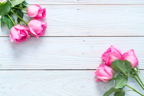 pink rose in vase on wood background - Foto, afbeelding