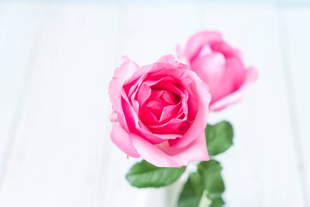 pink rose in vase on wood background - Foto, Imagem