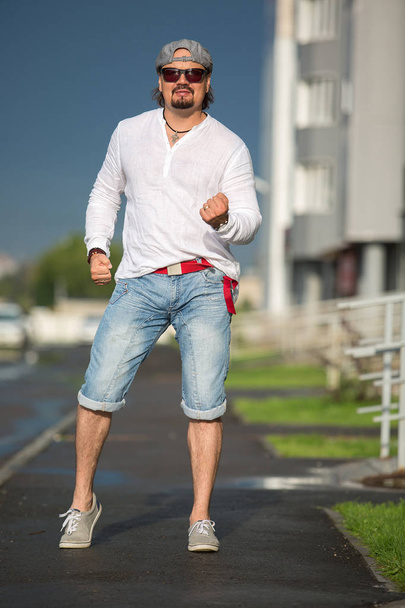 Ένας άνθρωπος είναι το περπάτημα στην αυλή σε μια ηλιόλουστη ημέρα. Lifestyle, mov - Φωτογραφία, εικόνα