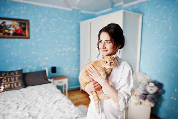 Bride posing with her cat inside her house before the wedding ce - Foto, imagen