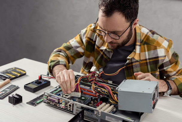 man adjusting details while fixing computer   - Fotografie, Obrázek