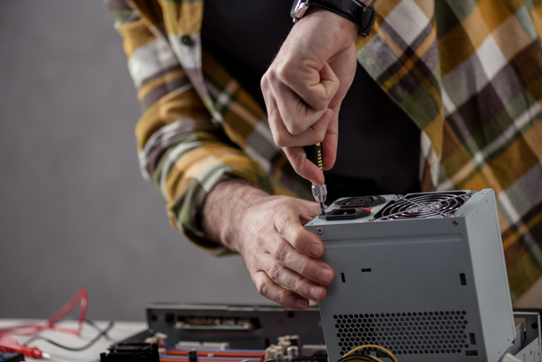 cropped image of man with screwdriver fixing computer part - 写真・画像