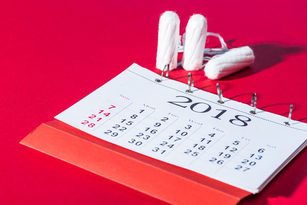 cotton feminine tampons and calendar on red - Foto, Imagem