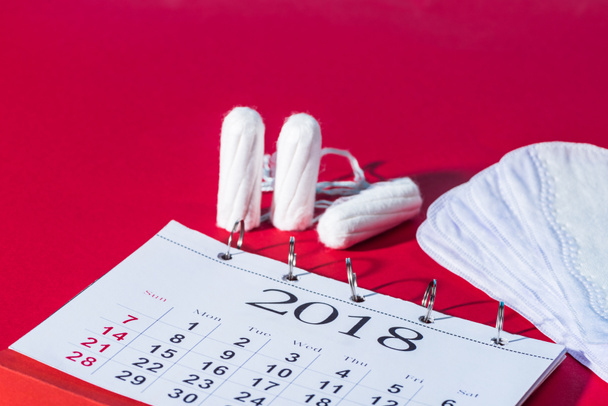 tampons, daily liners and calendar on red - Photo, Image