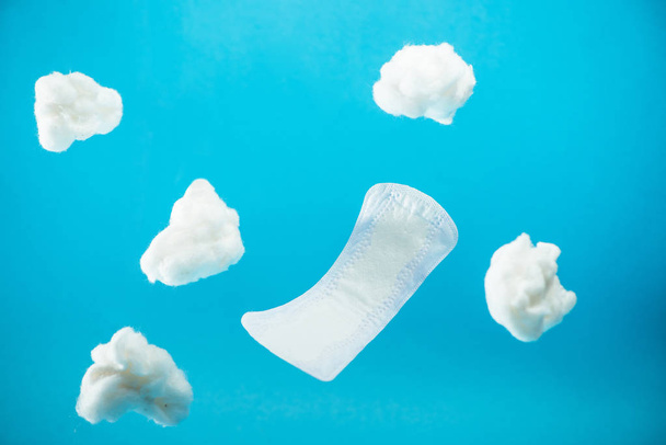 falling daily pad and pieces of cotton isolated on blue - Photo, Image