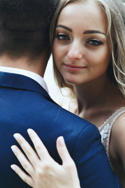 Portrait of beautiful bride leaning to groom's shoulder tender - Фото, зображення