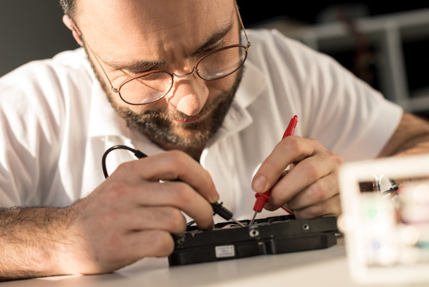 hombre usando multímetro mientras prueba la unidad de disco duro
    - Foto, imagen