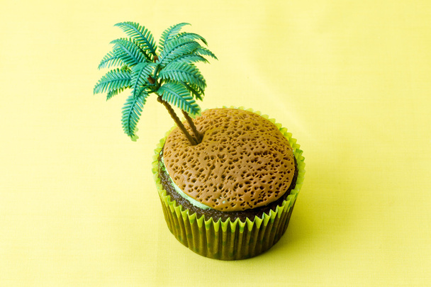 κοντινό πλάνο εικόνα του cupcake με ένα μικροσκοπικό δέντρο πλαστικό καρύδας - Φωτογραφία, εικόνα