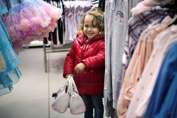 Bambina che guarda nel negozio per le vendite
 - Foto, immagini