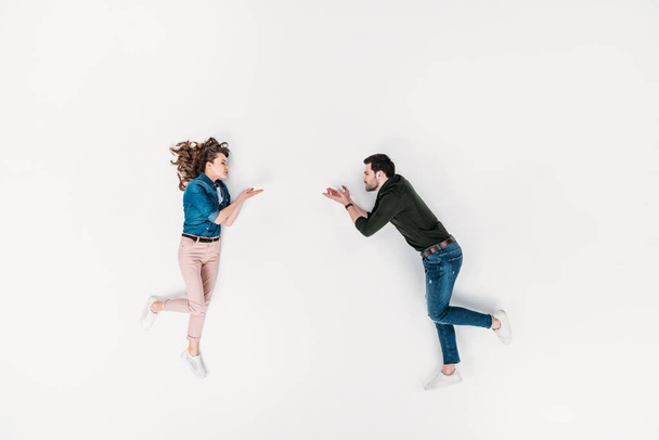 top view of woman throwing blown kiss to boyfriend isolated on white - Photo, Image