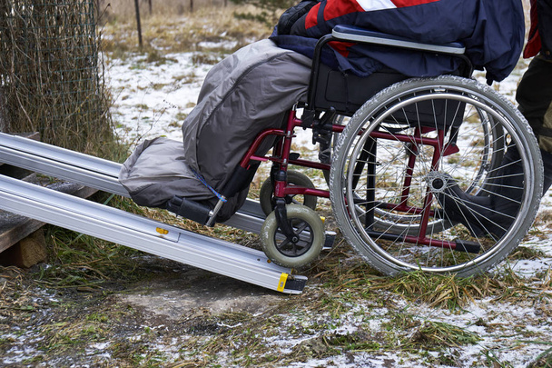 Llevar a una persona discapacitada en silla de ruedas a una casa de campo
 - Foto, imagen